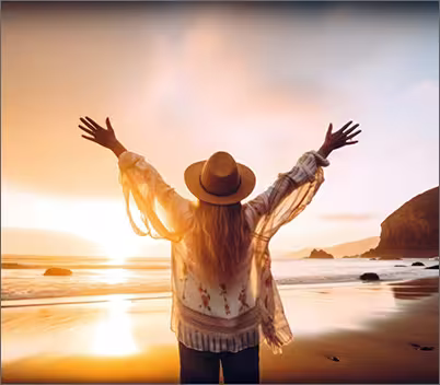 Women holding arms in air at sunset